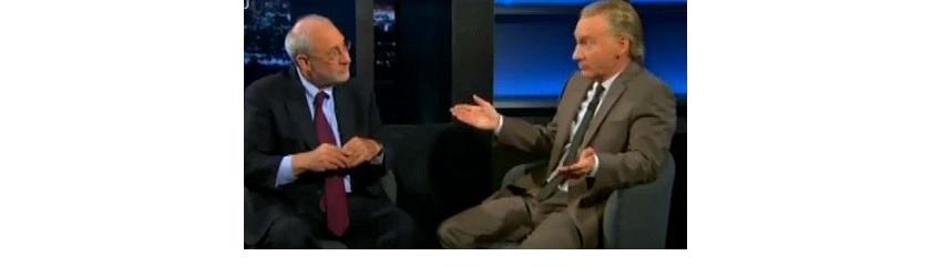 Joseph Stiglitz and Bill Maher looking at each other with blank looks